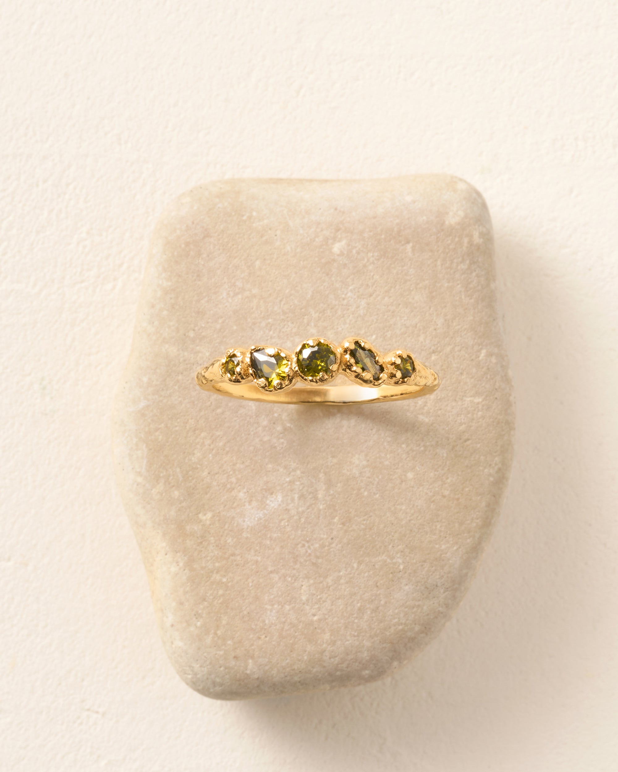 Koré green slim cluster ring with five dark green stones irregularly set in gold.