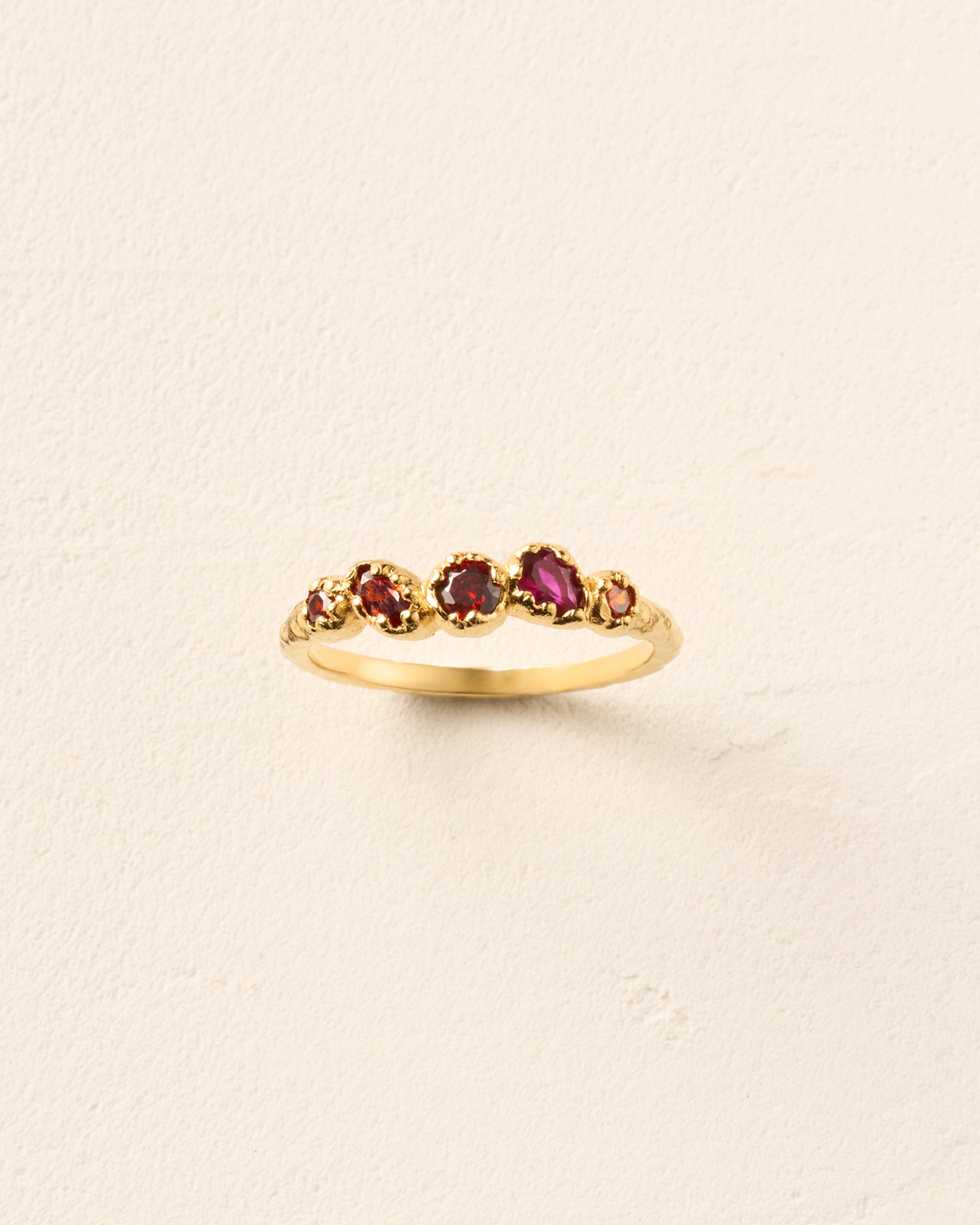 Koré Red Ring: Gold slim cluster ring with five irregular, natural red garnet stones.