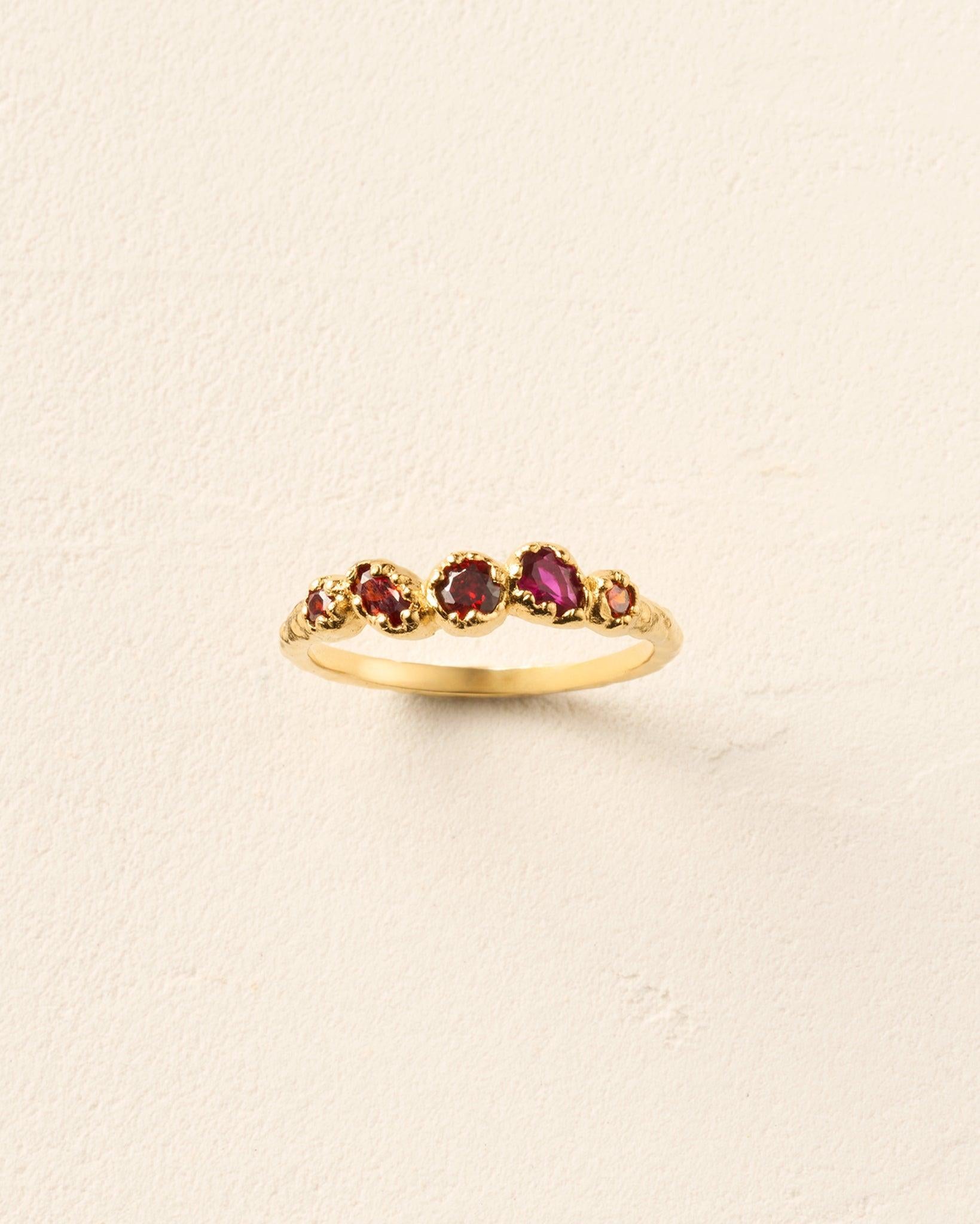 Koré Red Ring: Gold slim cluster ring with five irregular, natural red garnet stones.