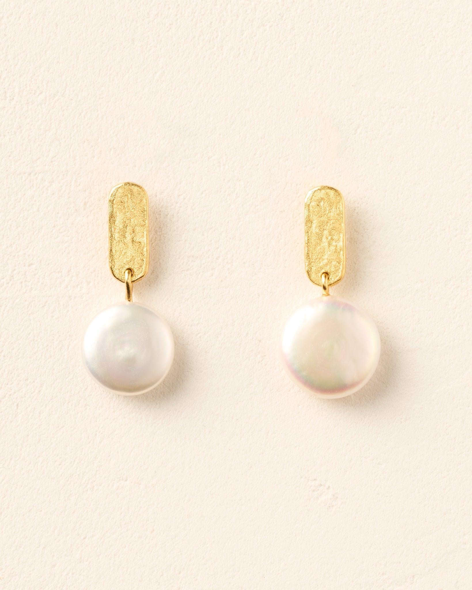Gold Perla earrings with textured bar studs and iridescent white baroque coin pearls.