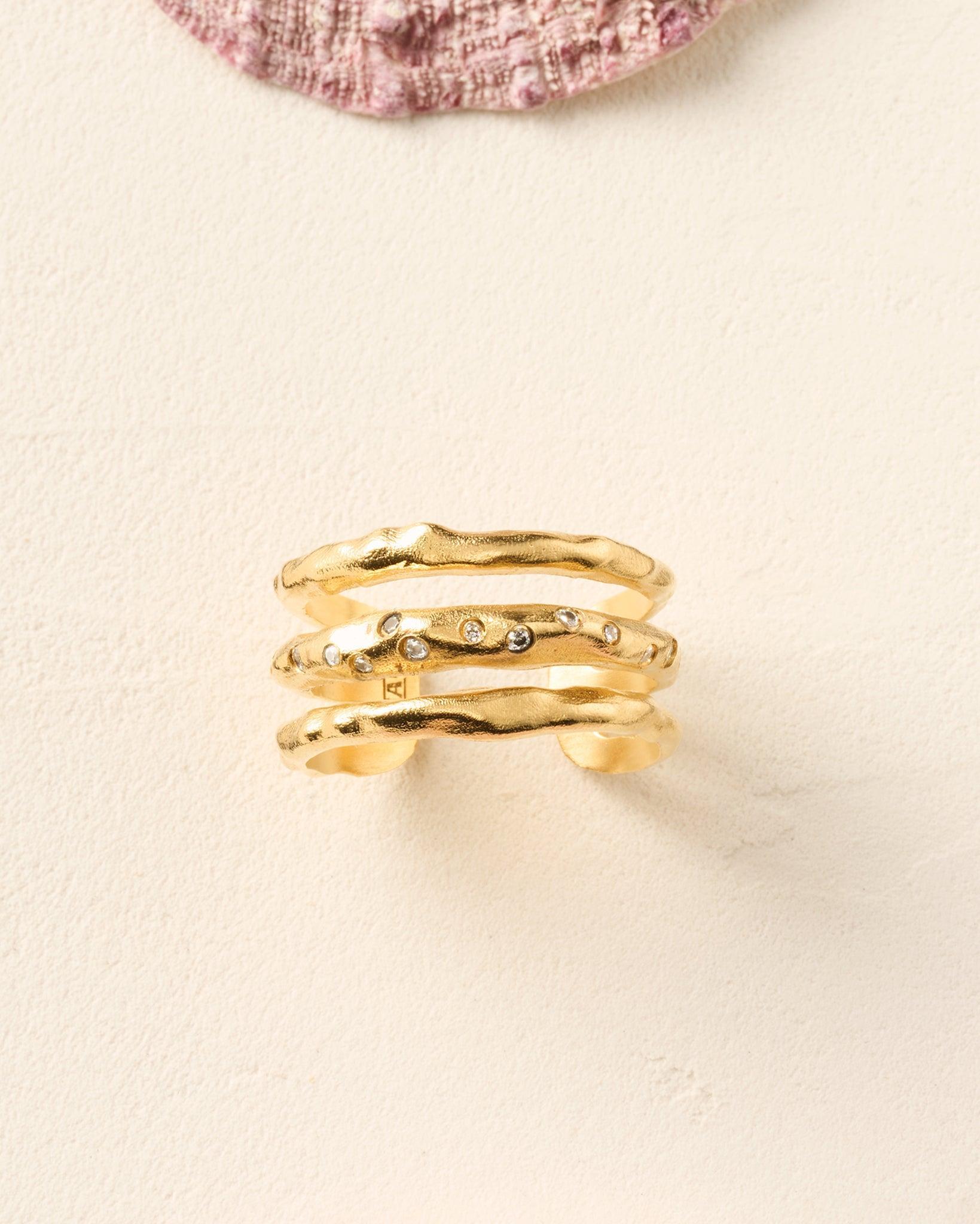Gold Iris ring with three irregular bands, the central one adorned with white stones.