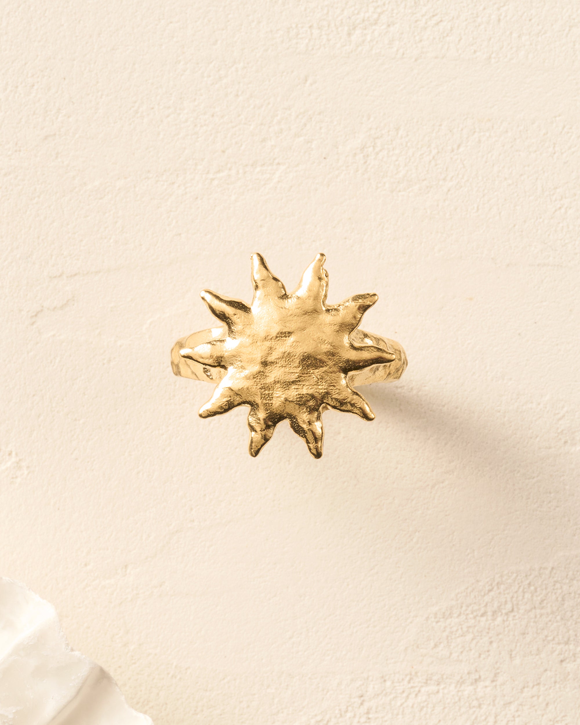 Gold Solé Ring with a sculpted sun on a hammered band, softly domed.