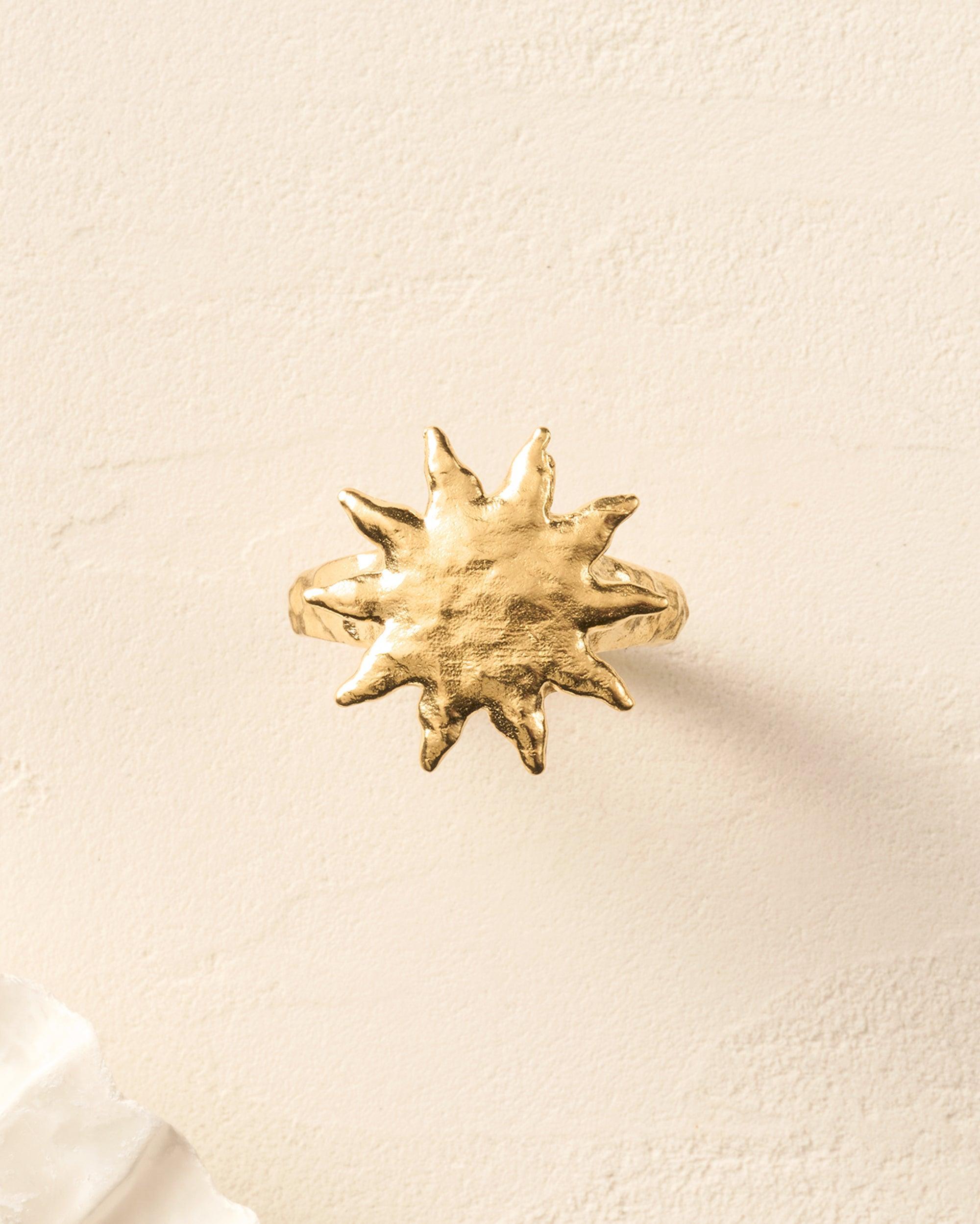 Gold Solé Ring with a sculpted sun on a hammered band, softly domed.