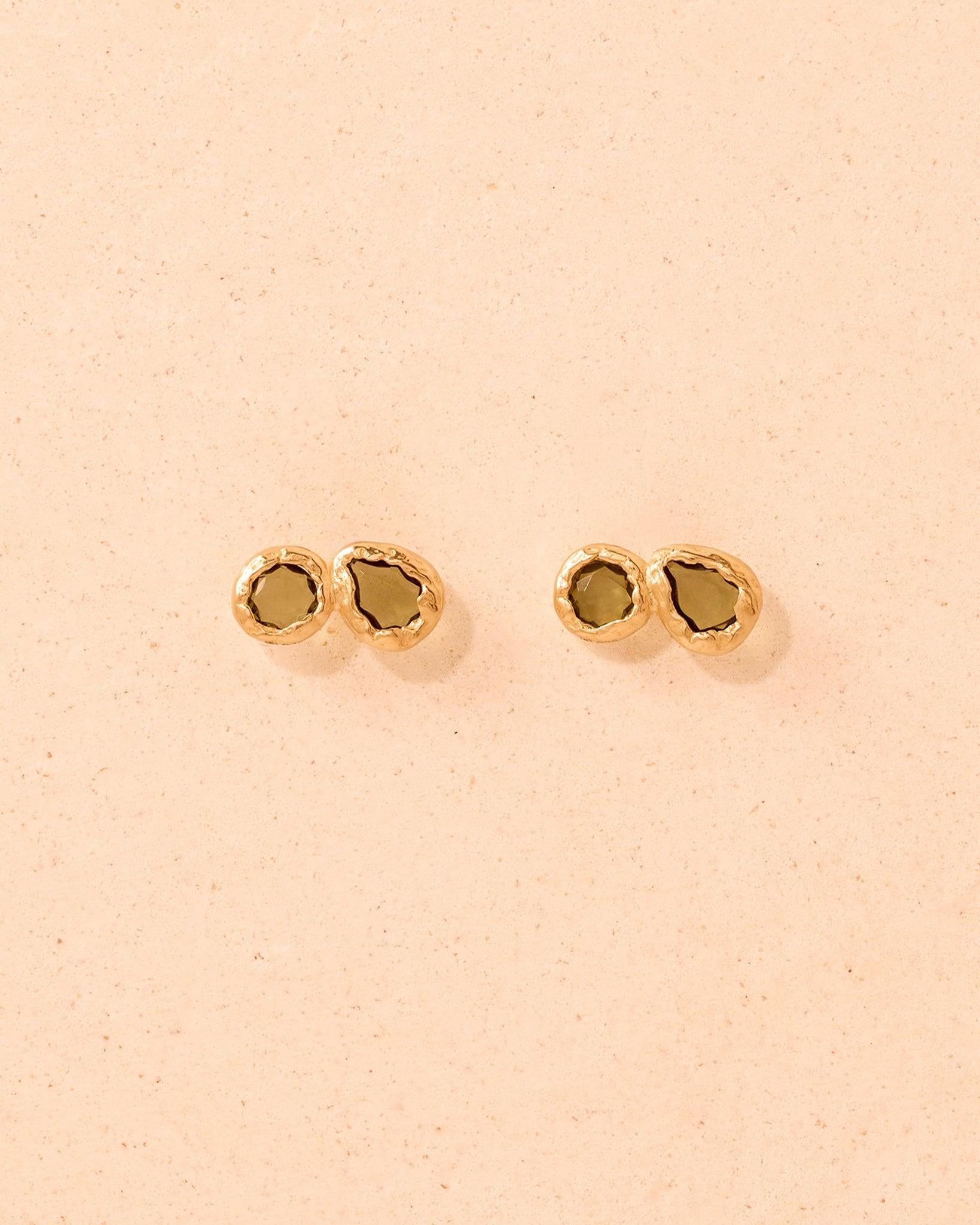 Lysiana earrings: gold-textured drop studs with dark-green hand-set stones.