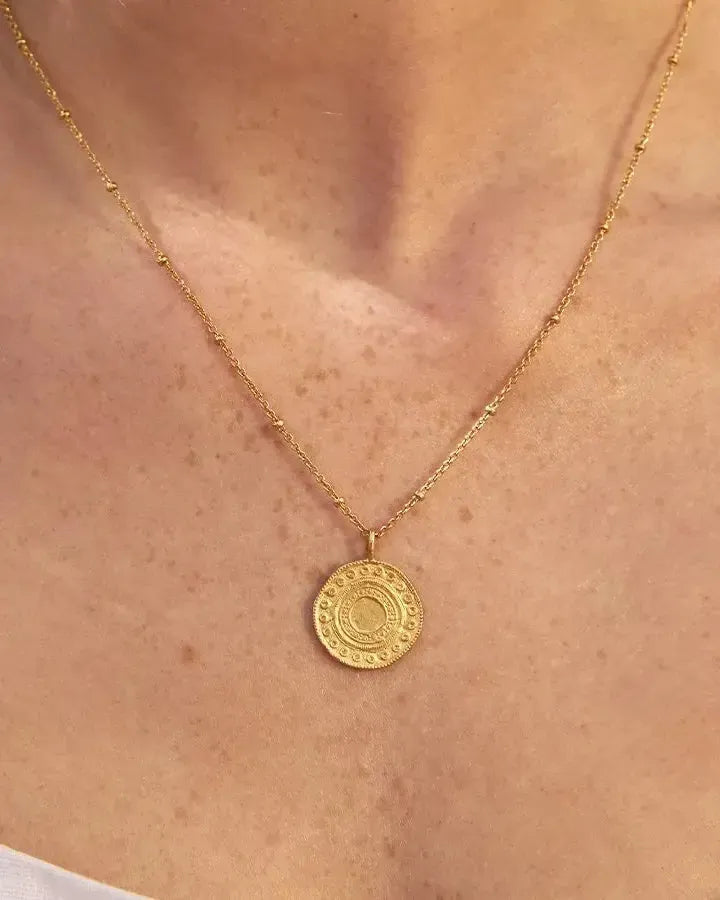 Gold-plated Alba necklace with a round, intricately detailed Persian-inspired pendant on a delicate beaded chain.
