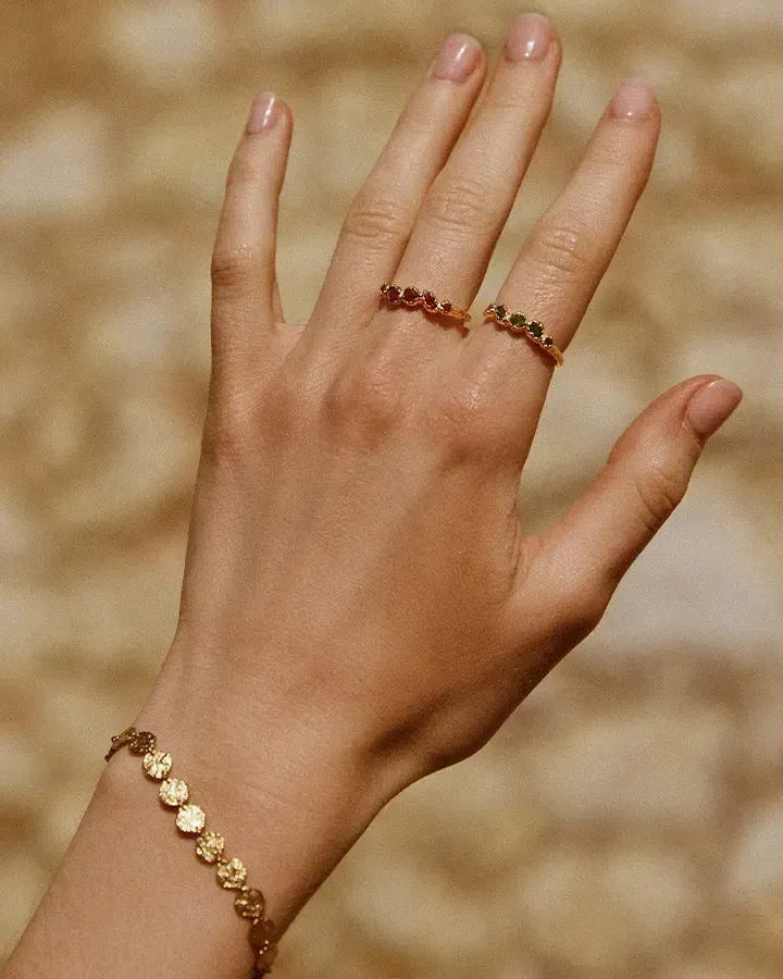 Koré Red Ring: Gold slim cluster ring with five irregular red garnet stones.