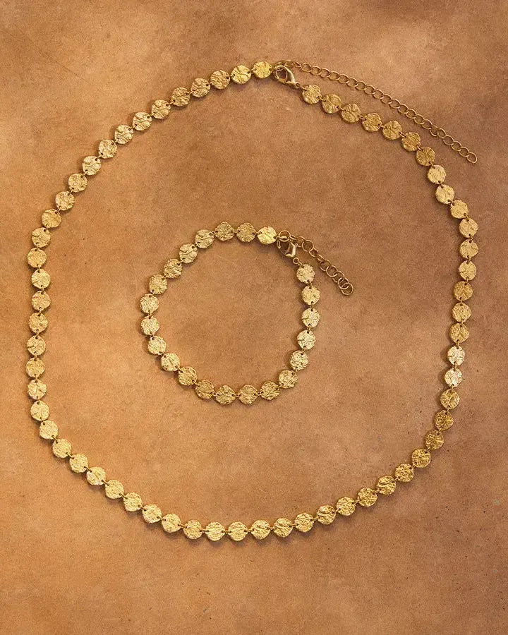 Caius gold necklace and matching bracelet with hammered discs, resembling ancient coins.