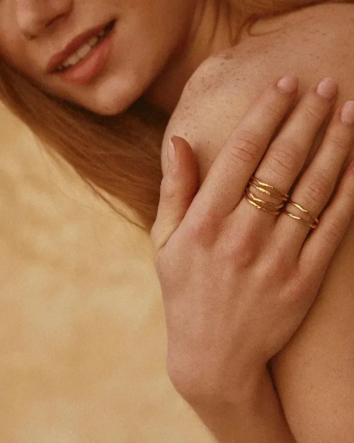 Léna twin ring: gold-toned, irregular stacked bands on a hand.