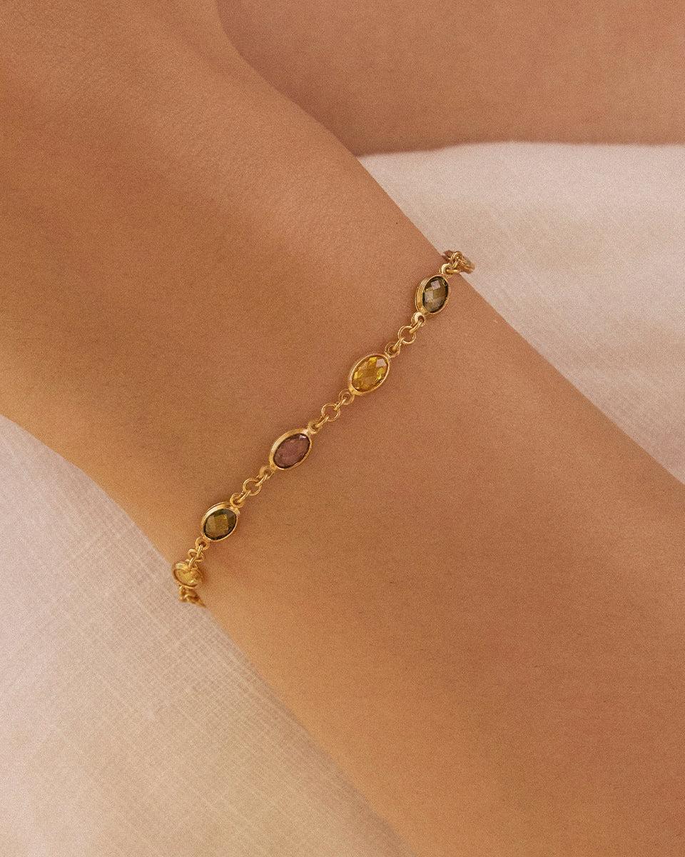 Fruitera Autumna gold chain bracelet with alternating rosewood, golden yellow, and dark green oval stones on a wrist.