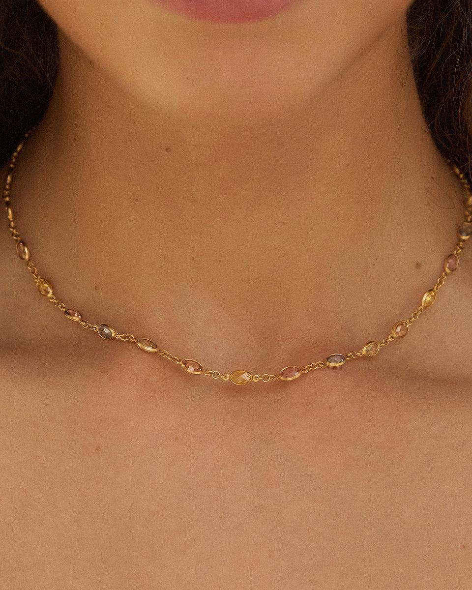 Fruitera Primavera necklace with alternating yellow, pink, blue, orange, and green stones on a fine gold chain.