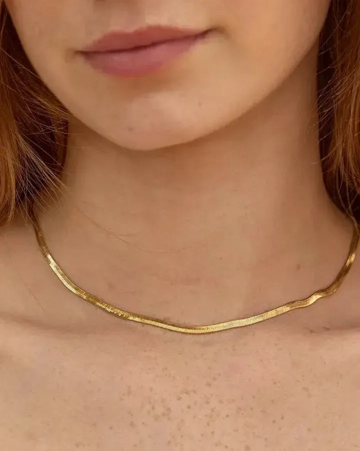 Orphée Choker: Gold-plated round choker with herringbone braids, worn on a woman's neck.