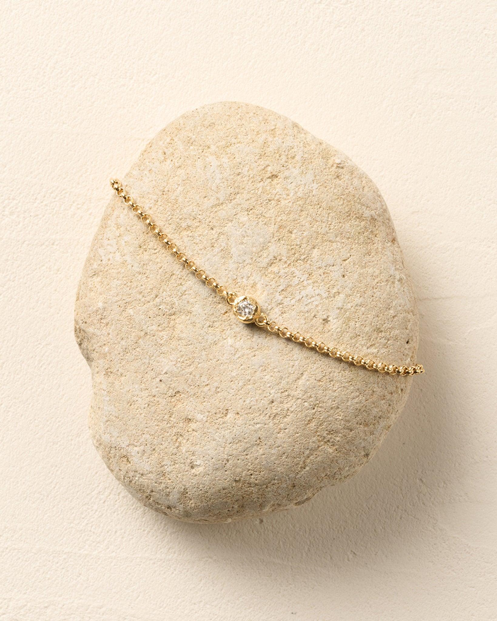 Ada Bracelet: Thin golden rolo chain with a single round lab-grown diamond in an irregular golden bezel.
