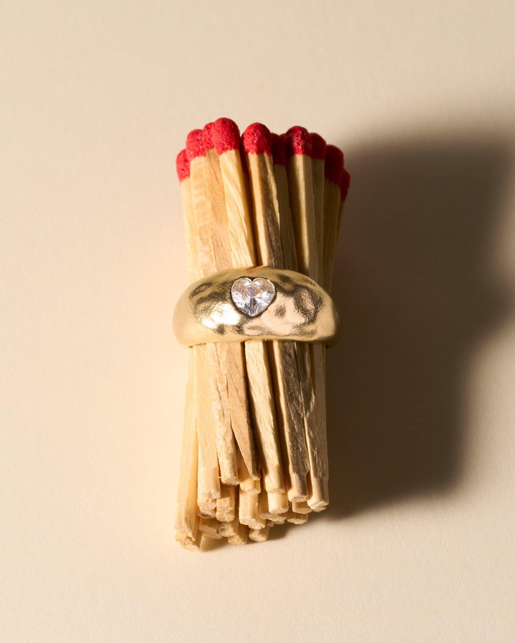 Luzia Ring: Domed, slightly hammered gold ring with a white heart-shaped stone.