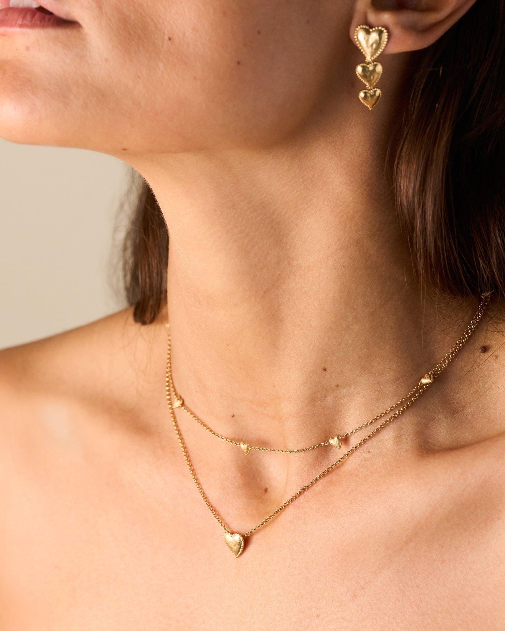 Amori Choker: Golden heart necklace with hammered, domed hearts and beaded halo, worn with matching earrings.