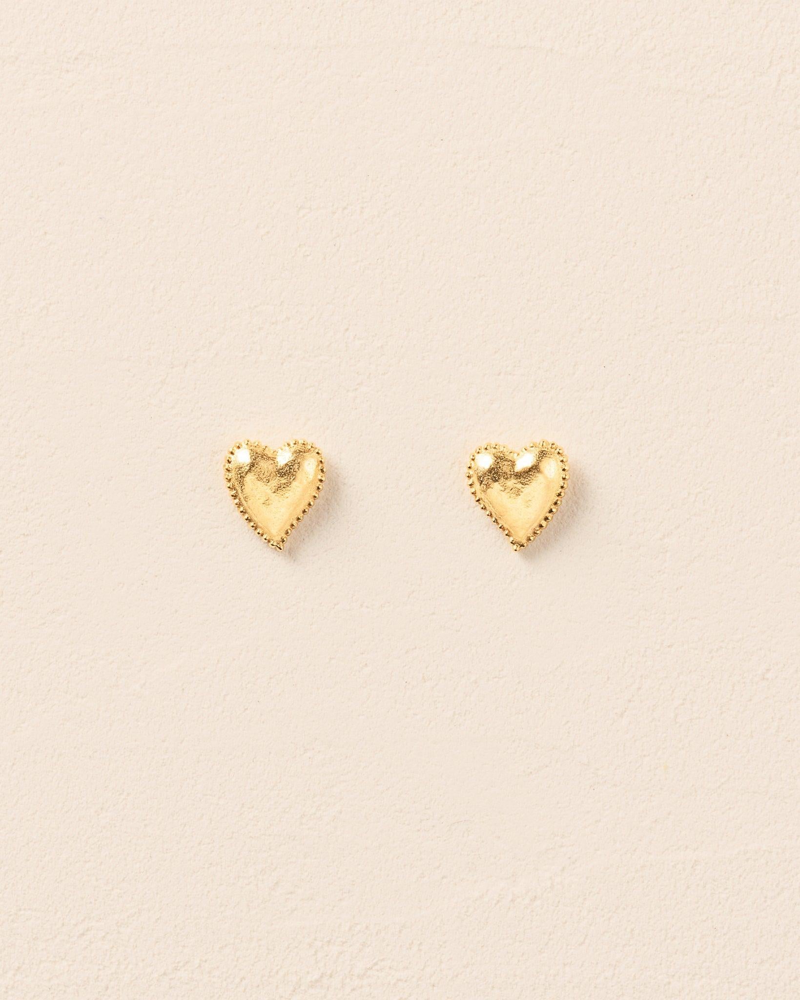 Pair of small gold heart stud earrings with hammered texture and beaded halo.