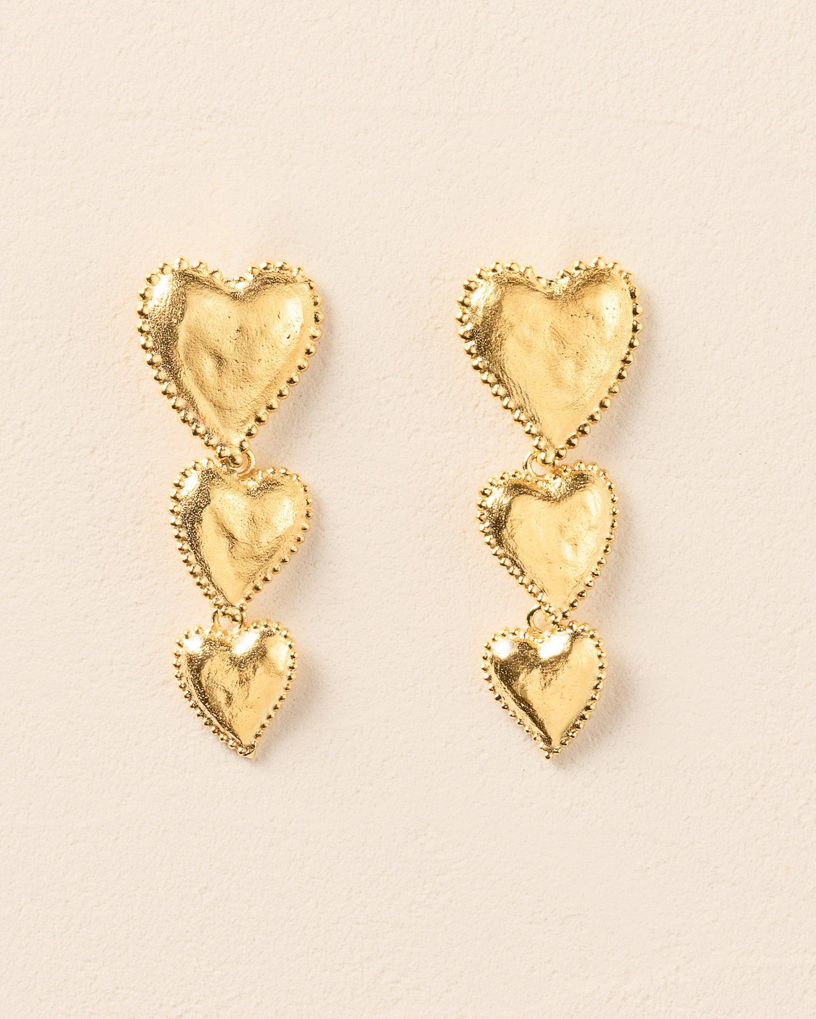 Gold Amori Trio earrings with three stacked, hammered heart drops and beaded halos.