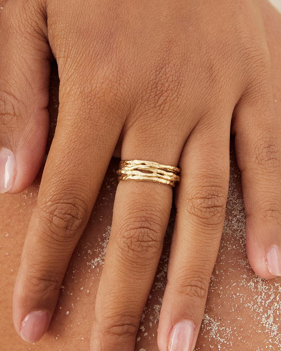 Gold Coral ring with organic, textured lines on a hand, inspired by deep-sea corals.