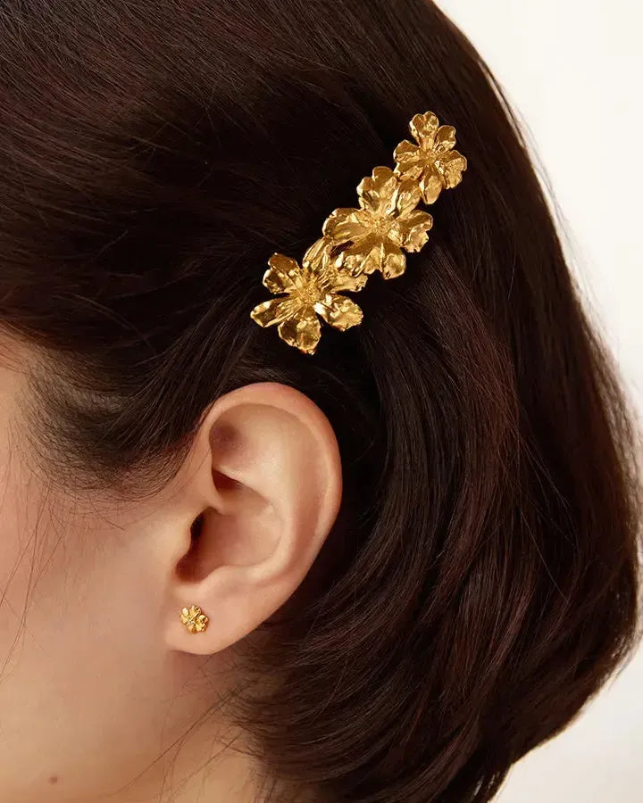 Gold floral hair clip with three flowers and a matching small Aleli stud earring.