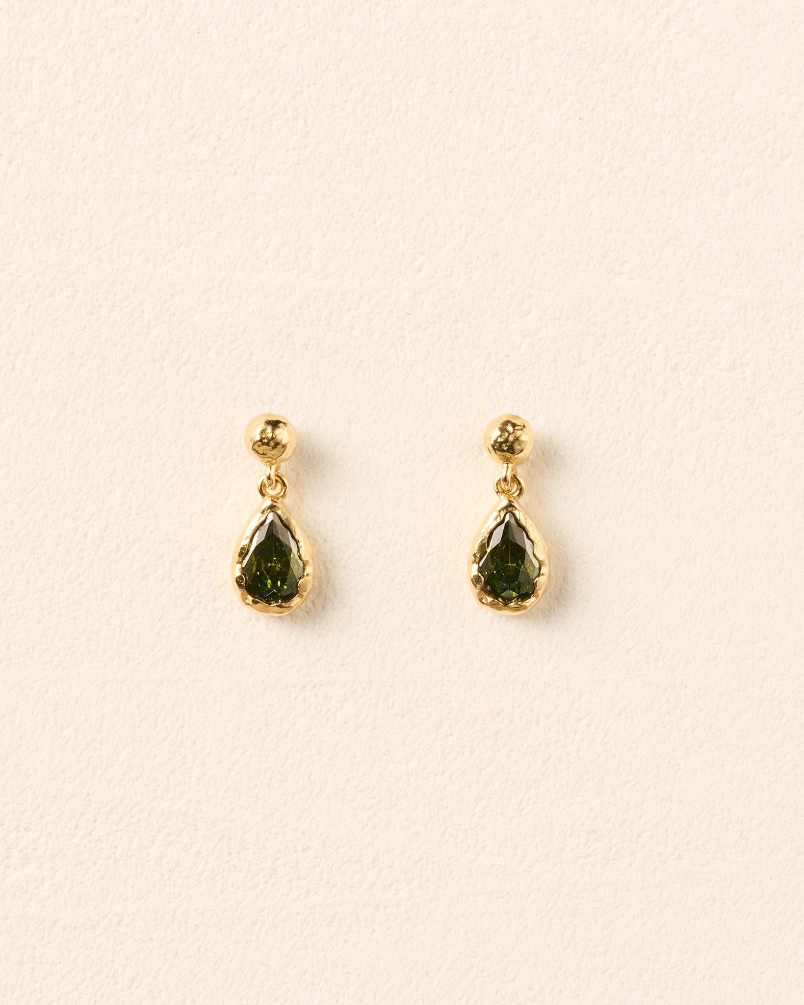 Lyséa drop earrings featuring dark green pear-shaped stones set in textured gold, suspended from hammered gold studs.