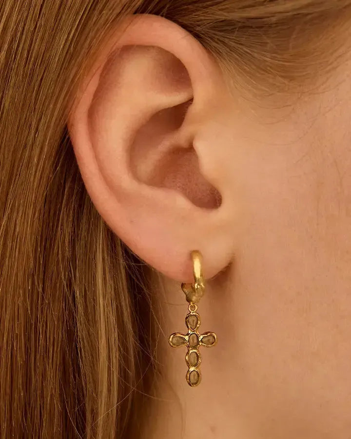 Nexa gold mini hoop earring with a cross pendant featuring oval green stones.