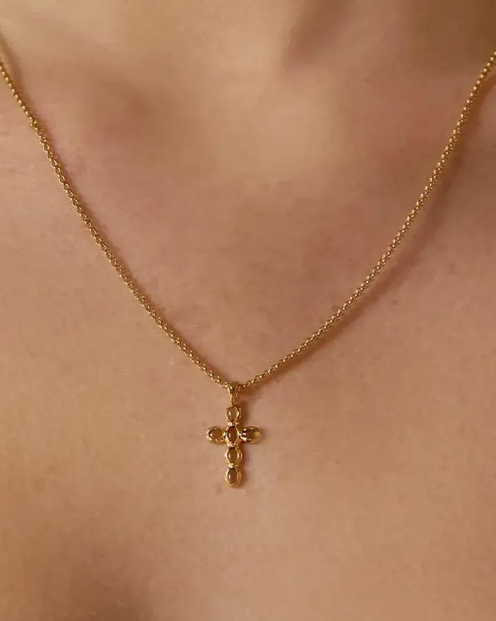 Gold Nexa Necklace with a small cross pendant featuring oval green stones.
