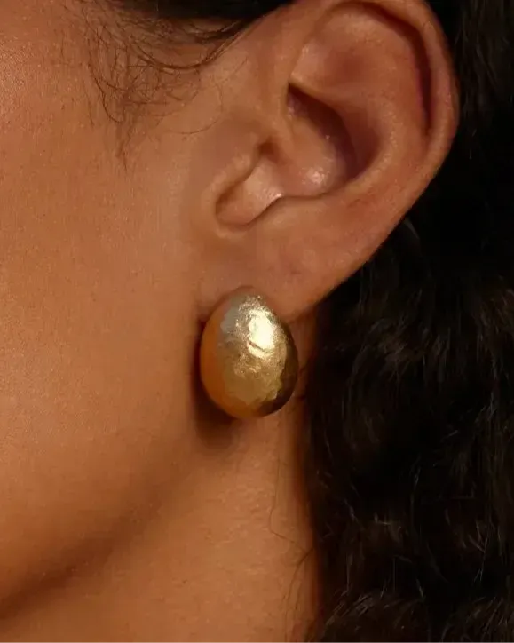 Figuera sculptural gold drop earrings with a domed, fig-inspired shape on an ear.