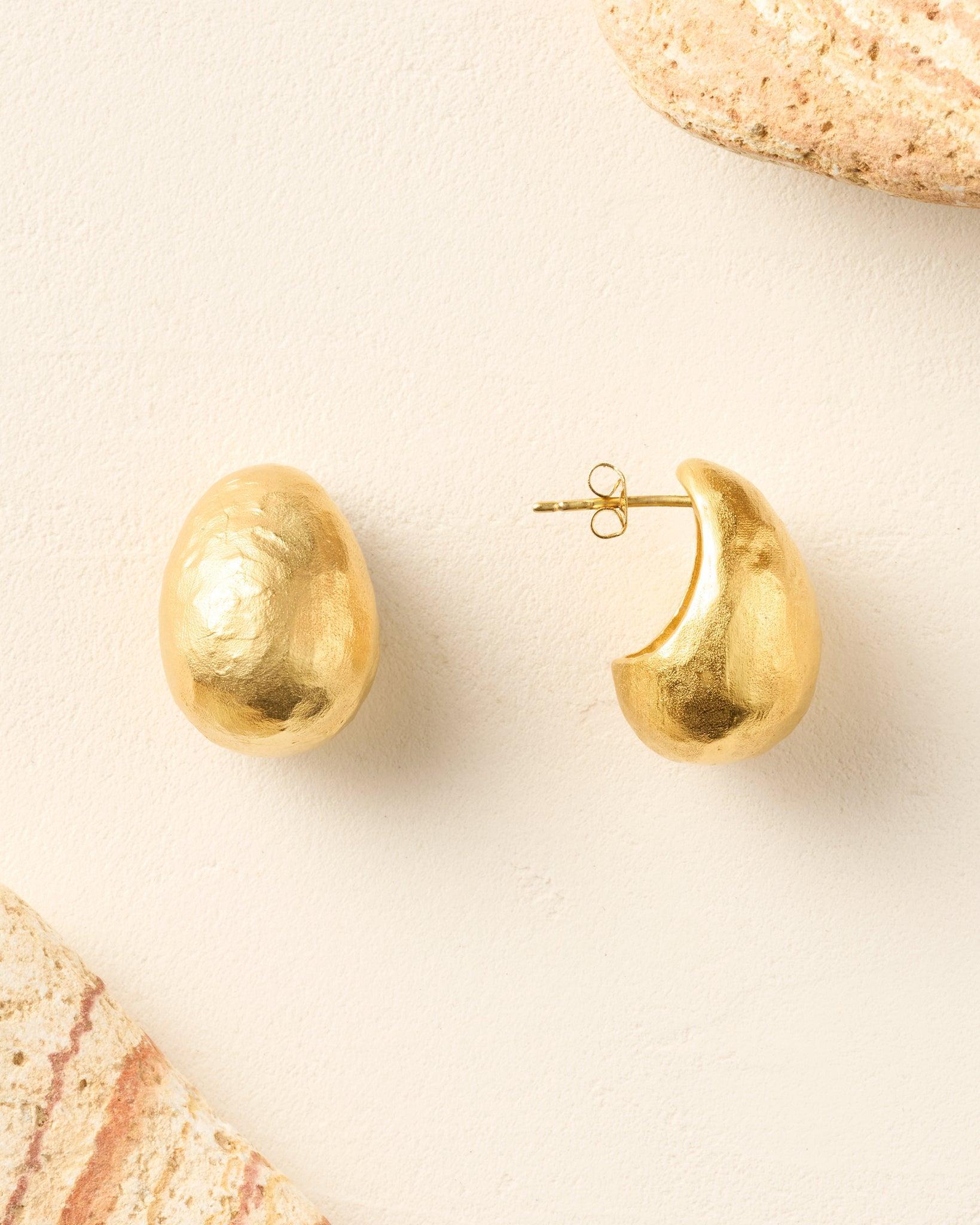 Sculptural gold Figuera earrings with a domed, drop-like shape, inspired by a fig.