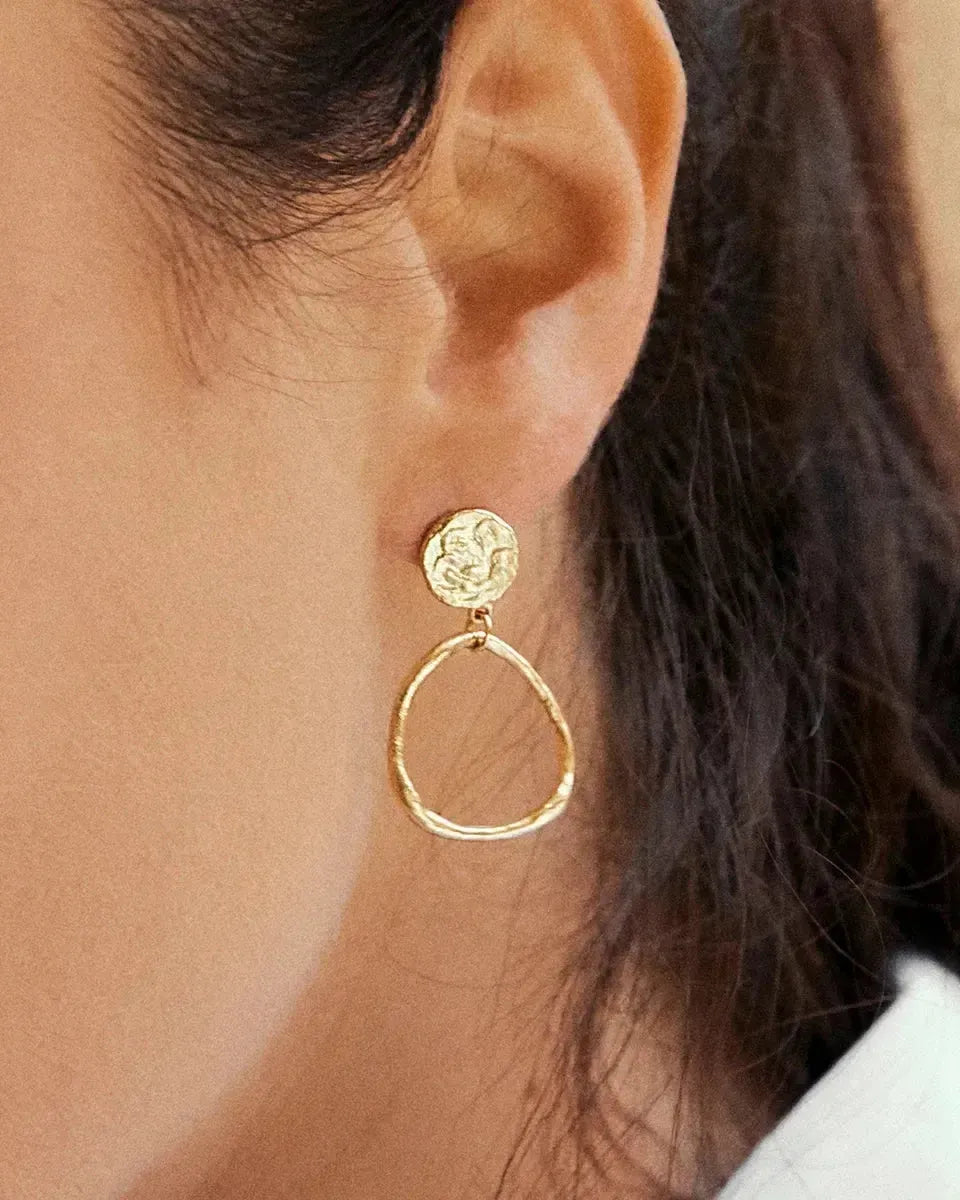 Nerea gold-toned earrings with a textured circular stud and an irregular, hammered hoop.