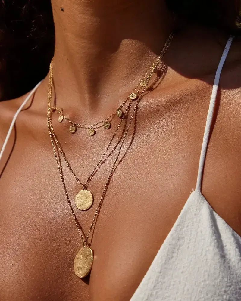 Gold Luna Necklace with hammered full moon pendants on a woman's chest.
