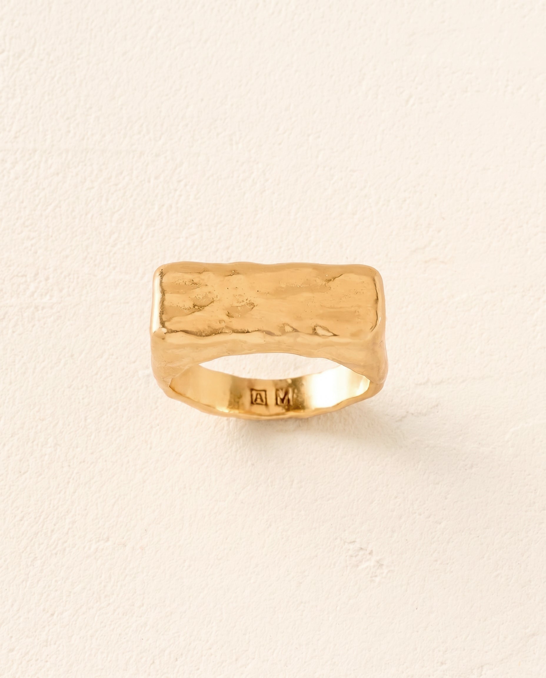 Chunky gold hammered rectangle signet ring with a rough, bold texture.