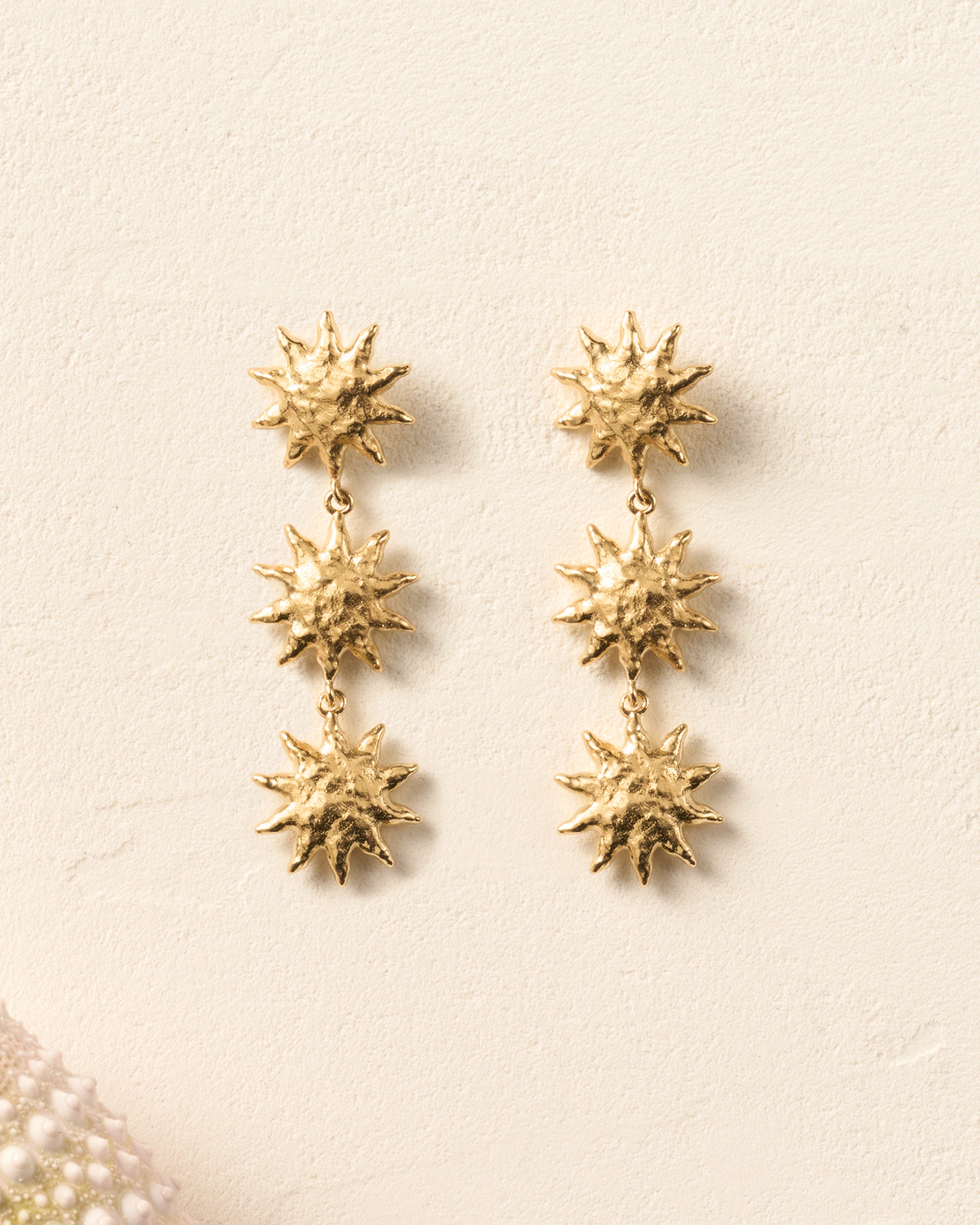 Gold Soléos sun drop earrings with three cascading, hammered, domed suns.