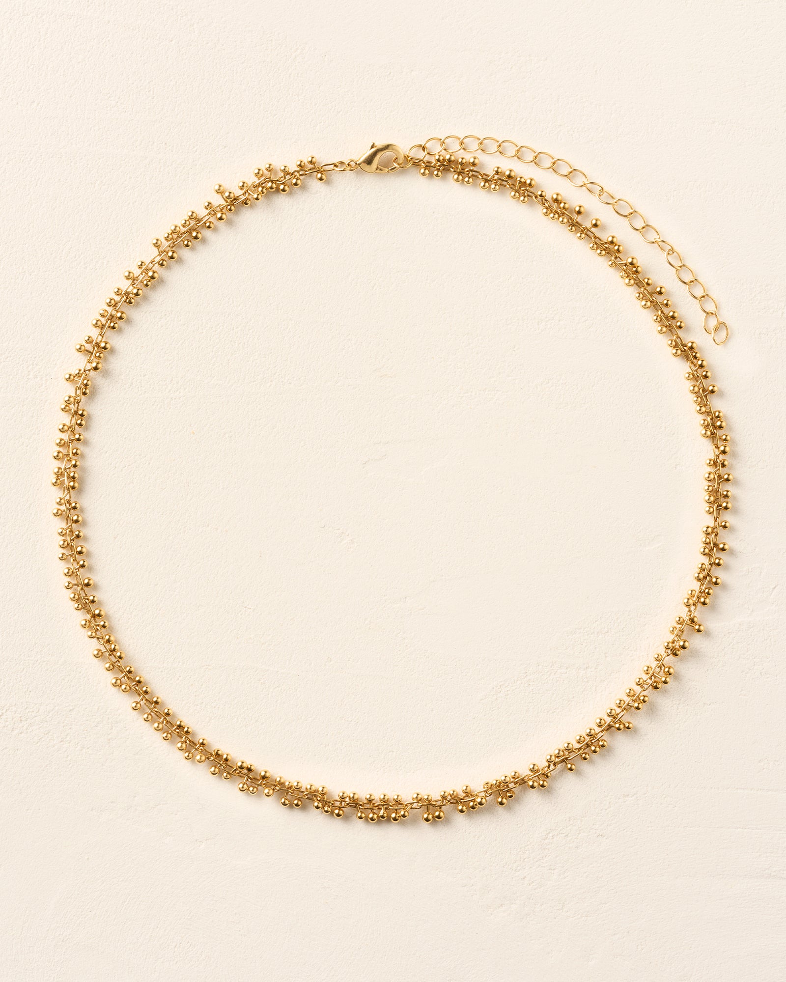 Achille Choker: Elegant gold-tone necklace with small beaded details and an adjustable chain clasp.