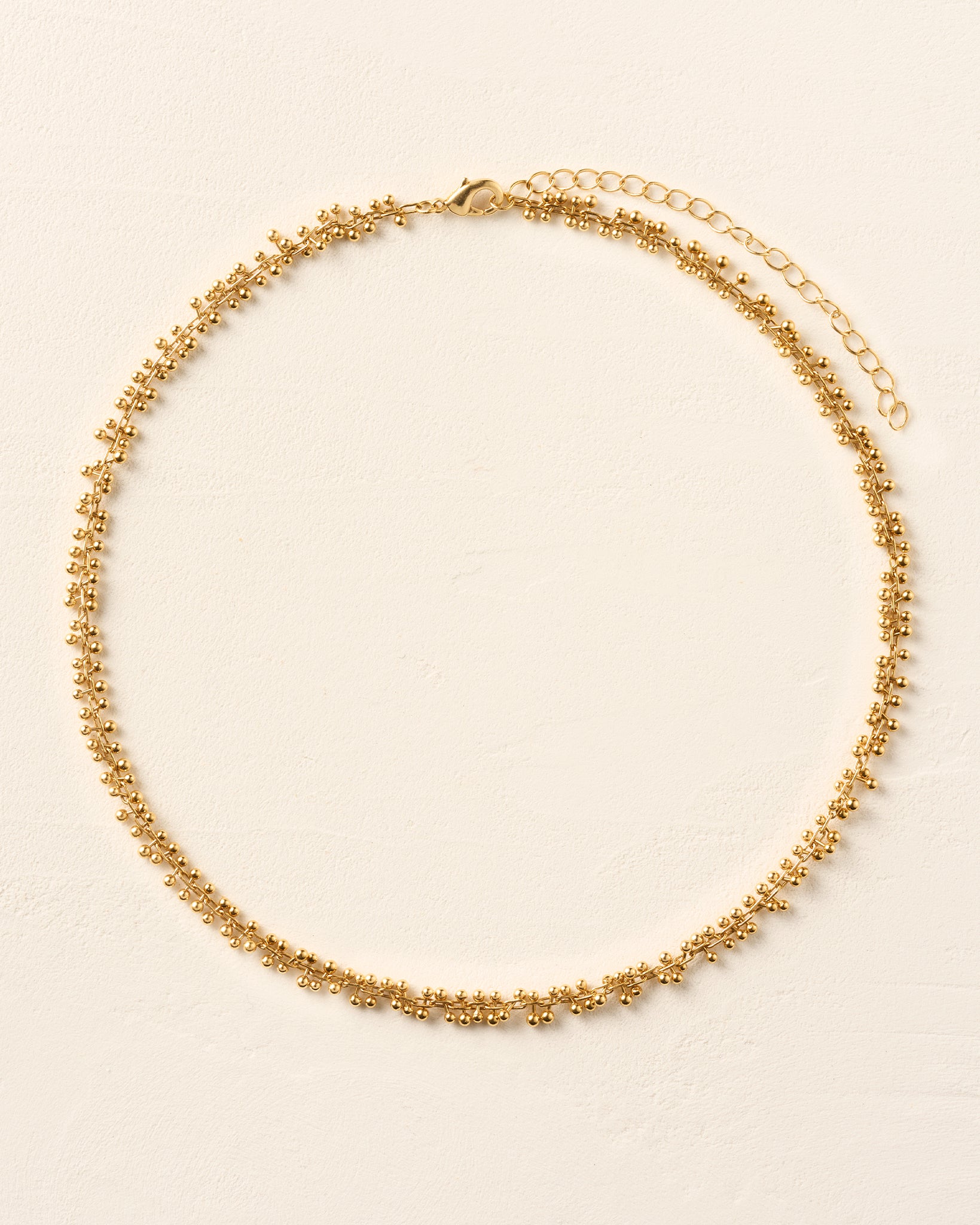 Achille Choker: Elegant gold-tone necklace with small beaded details and an adjustable chain clasp.
