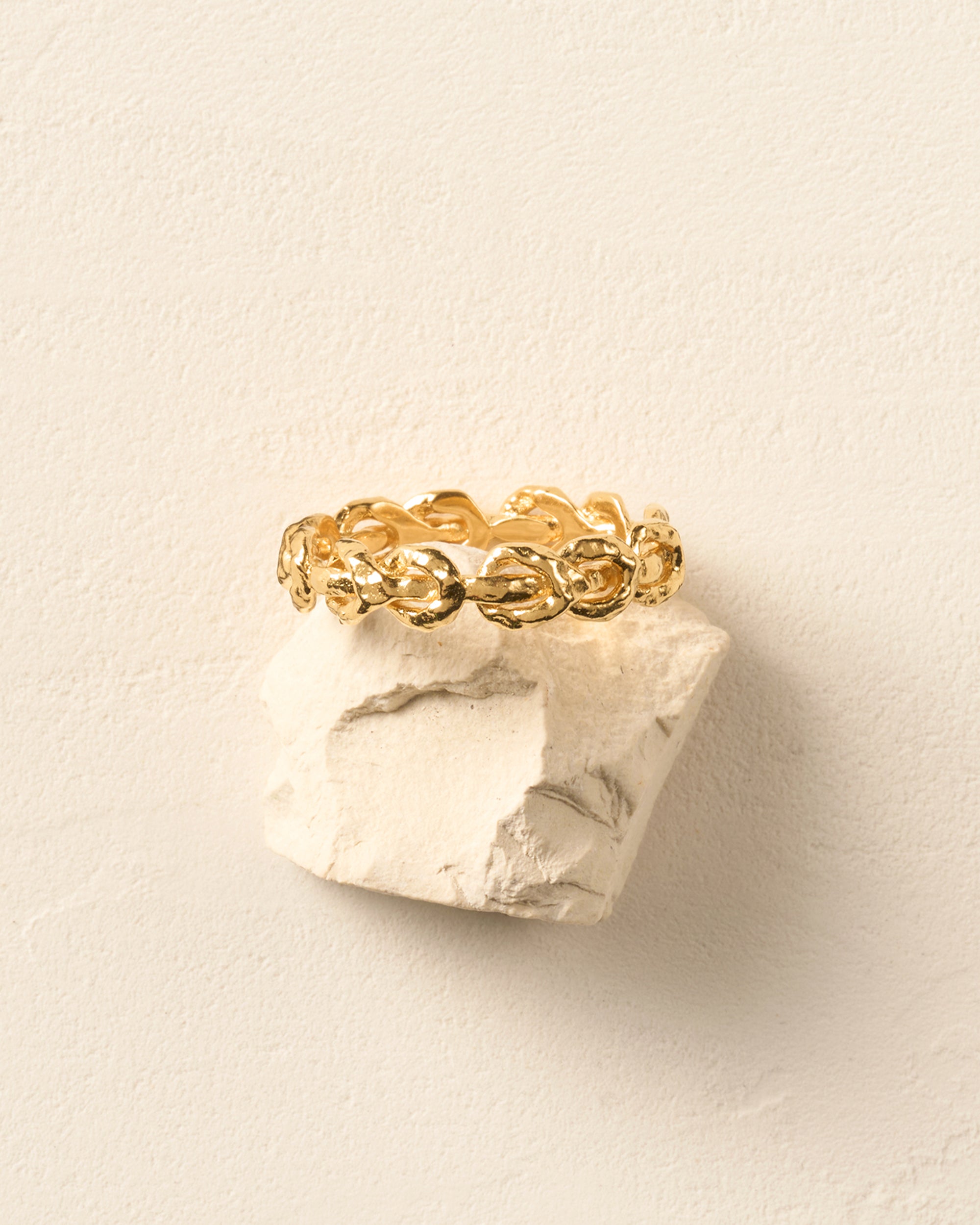 Gold hammered knot ring with interlocking reef knots, creating a twisted rope pattern.