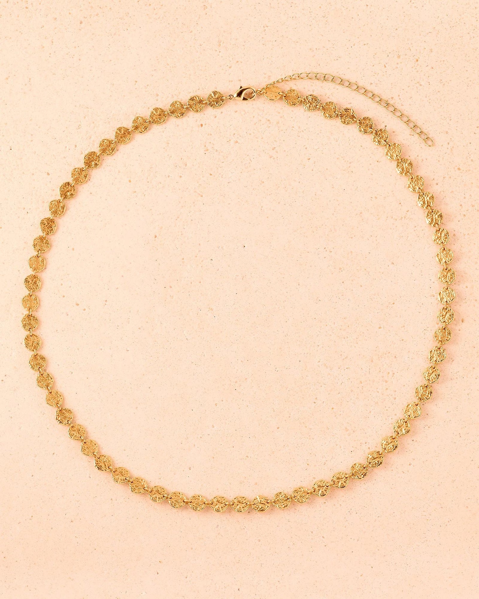Caius Halskette: Goldfarbene Halskette mit kleinen, gehämmerten goldfarbenen Scheiben in durchgehendem Design.
