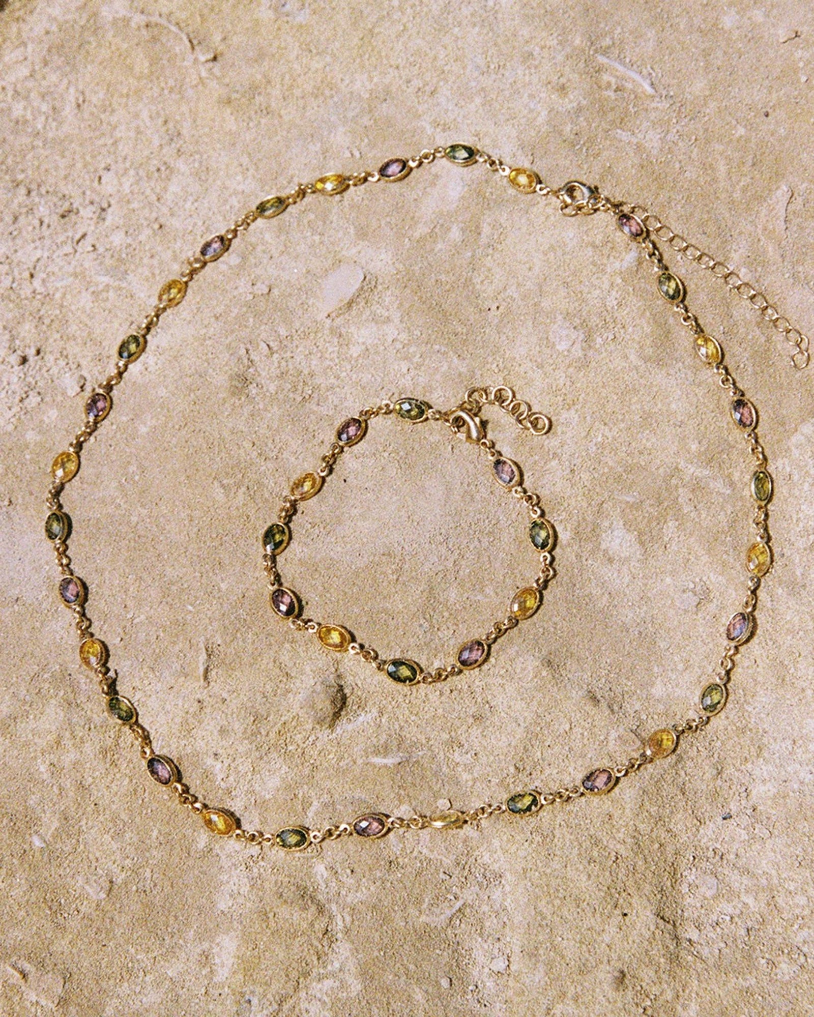Fruitera Autumna bracelet and necklace set with alternating rosewood, golden yellow, and dark green stones on a fine gold chain.