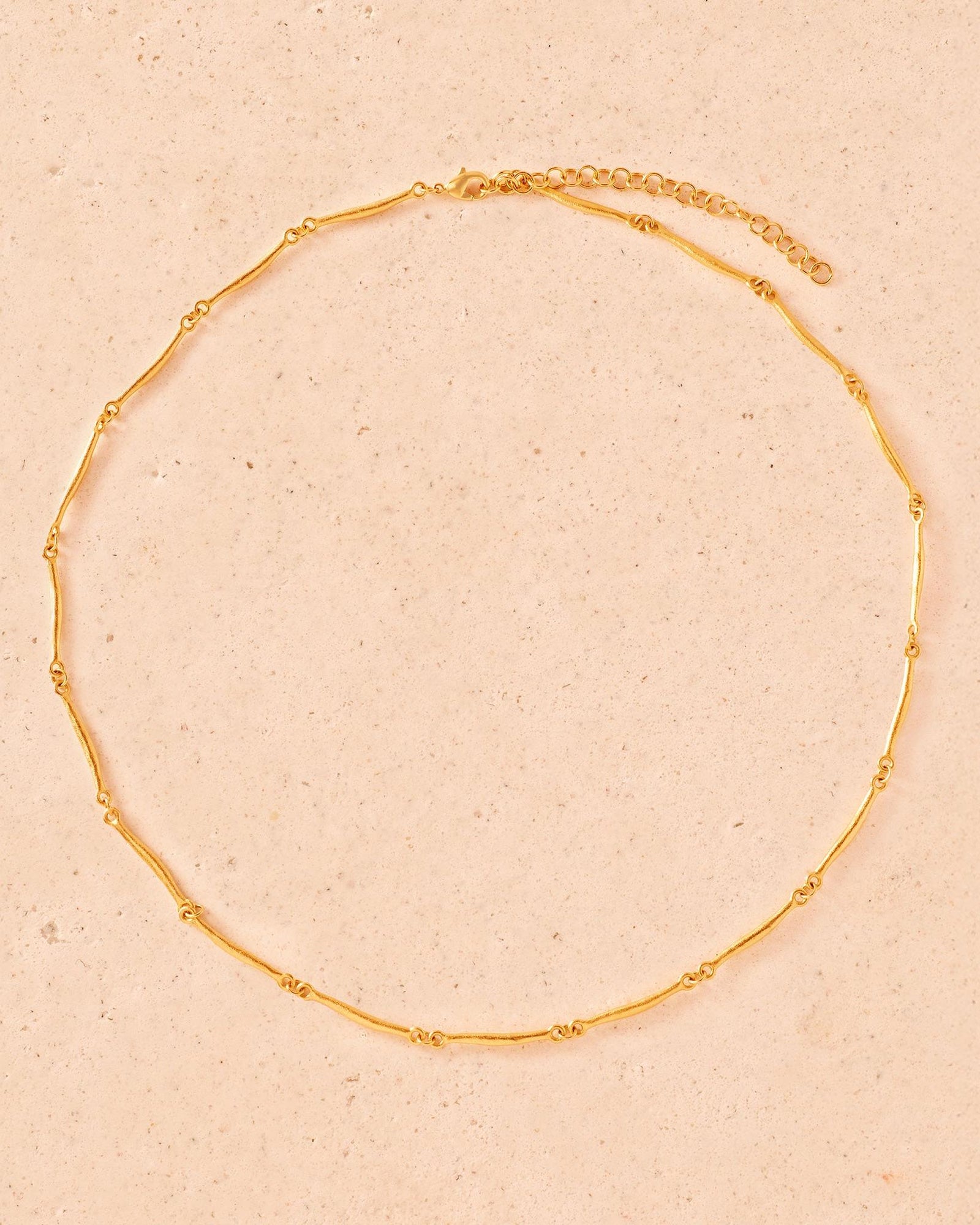 Enea gold-toned necklace with slim, hammered, irregular bar-shaped links and an adjustable chain.