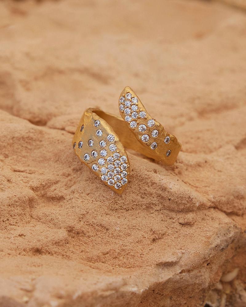 Rhéa open gold ring with irregularly inlaid white stones, designed like an elegant ribbon.