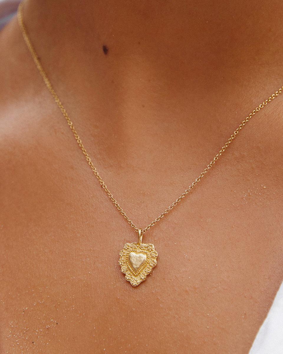 Aphrodite gold vintage heart necklace with intricate detailing on a delicate chain.