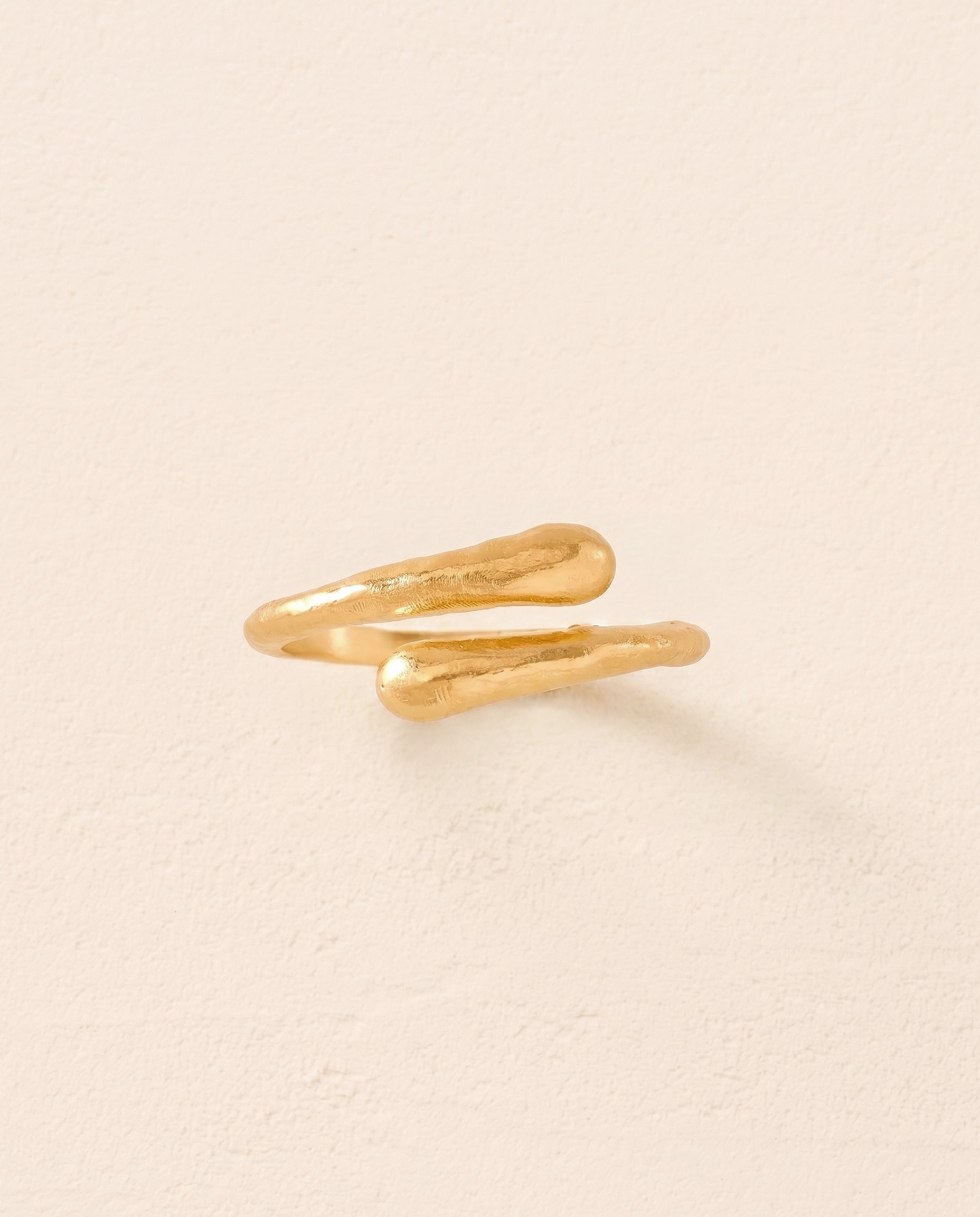 Gold Filippa Mini Ring with a bended arc and bold crossover curves.