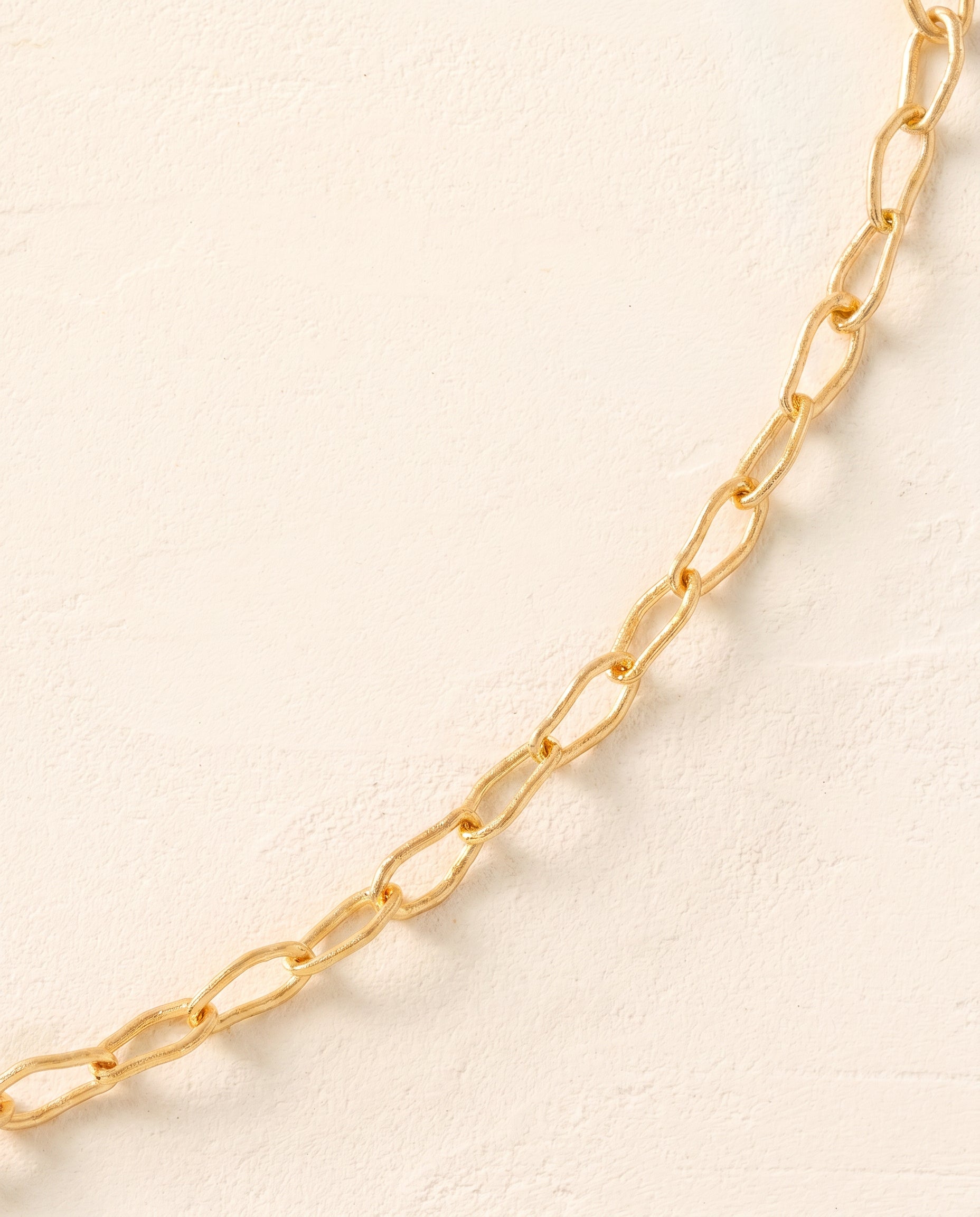Gold Horace Mini Choker with intertwined links and sleek toggle clasp, shown on a light background.